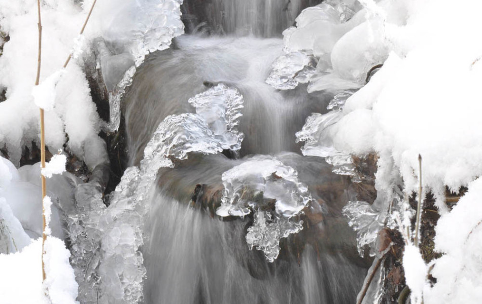 Gefrorener Wasserfall eines kleinen Wiesenbaches